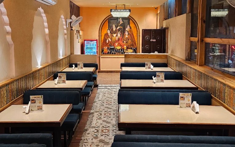 The empty dining room at Kund with its booths, patterned floor and mural